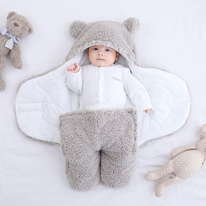 Niemowlę w pluszowym otulaczu z uszkami misia