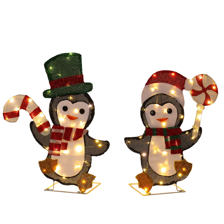 Dwa świecące pingwiny z laskami cukrowymi